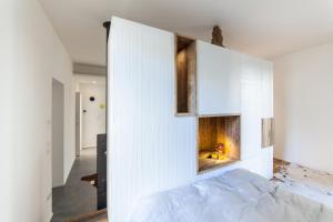 a bedroom with a white wall with a fireplace at @HOME - Mini In Centro Storico in Padova