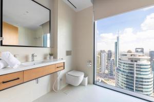 a bathroom with a toilet and a large window at Vida Dubai Marina & Yacht Club Residences in Dubai