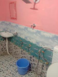 a bathroom with a shower and a sink and a bucket at Eden Homestay Sittong in Kurseong