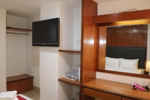 um quarto de hotel com uma televisão e um quarto em Hotel Seri Putra em Kuala Lumpur