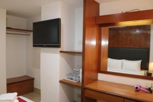 Una habitación de hotel con televisión y un dormitorio. en Hotel Seri Putra, en Kuala Lumpur