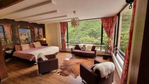 a bedroom with a bed and a large window at Termales Chachimbiro "Fuente de Vida" in Urcuquí