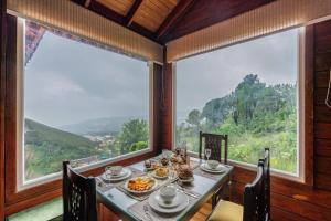 a dining room with a table and a large window at StayVista at Villa Vivendi - 4 BR villa in Dharamshala in Dharamshala