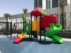 a playground with colorful play equipment in front of a building at Frank Porter - Bella Rose in Dubai