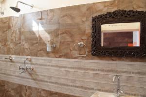 a bathroom with a mirror and a sink at Karma Heritage Guest House in Jodhpur