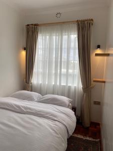 um quarto com 2 camas e uma janela em Warm and Inviting Mountain Cottage em Naro Moru