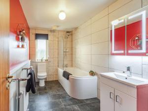 a bathroom with a tub and a sink and a toilet at 4 Bed in Warkworth 86132 in Warkworth +15 photos
