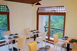 Chariot Square في كاندي: غرفة طعام مع طاولات وكراسي ونوافذ