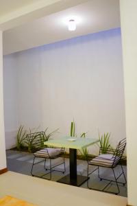 una mesa y sillas en una habitación con plantas en Chariot Square en Kandy