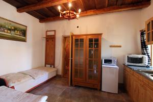 a small kitchen with a bed and a microwave at Toldi Vendégház in Felsőtold