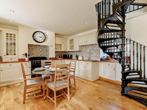 a kitchen with a table and a spiral staircase at 3 Bed in Seahouses CN153 in Seahouses