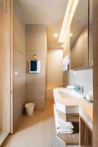 a bathroom with a white sink and a shower at Silom Nara in Bangkok