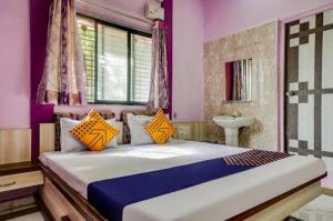 a bedroom with a large bed with orange pillows at Hotel Anupark in Sakri