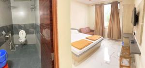 a bedroom with a bed and a bathroom with a toilet at Hotel Anupark in Sakri