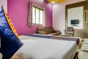 a bedroom with a bed and a purple wall at Hotel Anupark in Sakri