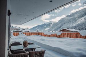 a balcony with a table and chairs in the snow at Studio Weitblick in Saalbach-Hinterglemm