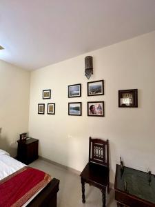 a bedroom with a bed and pictures on the wall at Supyar Mahal in Jaipur