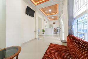ein Wohnzimmer mit einem roten Sofa und einem Tisch in der Unterkunft Urbanview Hotel Binwa Syariah Bandar Lampung in Hajimana