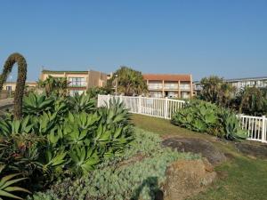 un jardin avec une clôture blanche et quelques plantes dans l'établissement Glenmore Sands Beach Resort, à Port Edward
