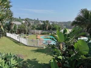 a view of a garden with a swimming pool at Glenmore Sands Beach Resort in Port Edward