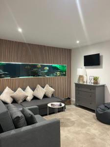 a living room with a couch and a flat screen tv at Terfyn Hall aquarium apartment 1 in Prestatyn