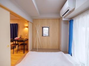 1 dormitorio con cama, escritorio y ventana en Dc桜の苑403和式双人房间, en Osaka