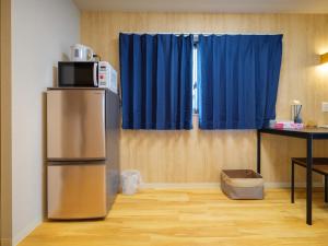 eine Küche mit einem Kühlschrank und einer Mikrowelle darüber in der Unterkunft Dc桜の苑403和式双人房间 in Osaka