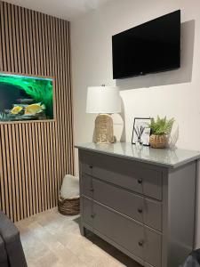 a room with a dresser with a lamp and a fish tank at Terfyn Hall aquarium apartment 1 in Prestatyn