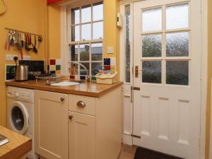 una cucina con pareti gialle e una porta bianca di Town Cottage a Skipton