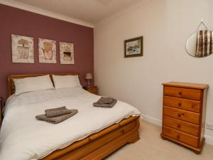 a bedroom with a large bed and a wooden dresser at Town Cottage in Skipton