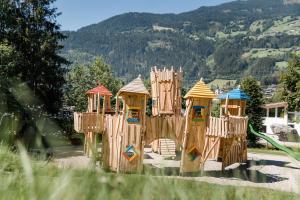 um grupo de estruturas de jogo de madeira em um parque em Chalet - Direkt am 5 Sterne Campingplatz Aufenfeld im Zillertal mit Hallenbad und Sauna em Aschau