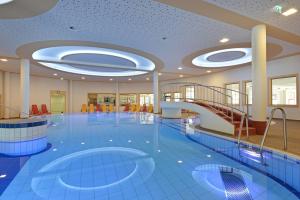 a large swimming pool with a staircase in a building at Chalet - Direkt am 5 Sterne Campingplatz Aufenfeld im Zillertal mit Hallenbad und Sauna in Aschau