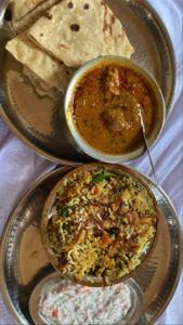dos platos de comida con salsa y pan de pita en Heritage Resort , Kolhapur, en Kolhapur