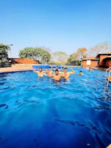 un grupo de hombres nadando en una piscina en Heritage Resort , Kolhapur, en Kolhapur
