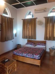 1 dormitorio con 1 cama y 2 ventanas en Heritage Resort , Kolhapur, en Kolhapur