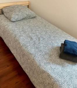 - un lit avec un oreiller bleu dans l'établissement Maison, proche de Lille et grand stade olympique, à Lezennes