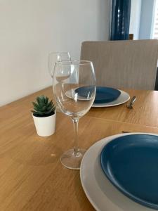 a wine glass sitting on top of a wooden table at Maison, proche de Lille et grand stade olympique in Lezennes