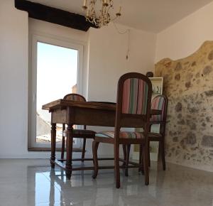 - une table et des chaises en bois dans une chambre avec fenêtre dans l'établissement Casa Mare * Monte * Mille Stelle, à Santa Caterina dello Ionio