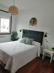 1 dormitorio con 1 cama blanca grande y cabecero negro en Alojamiento Santa Maria Bertamirans II, en Ortoño