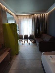 a living room with a couch and a green refrigerator at Barocco Island Studios in Skala Potamias