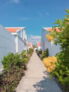 a walkway between two houses with flowers on it at TTC Resort Ke Ga in Ke Ga