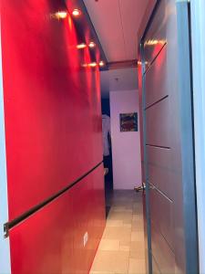 a red refrigerator in a room with a hallway at CLOCKWORKORANGE Luxury Suites 4-Minutes Away To Airport in Mactan