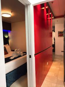 a red refrigerator in a room with a bed at CLOCKWORKORANGE Luxury Suites 4-Minutes Away To Airport in Mactan