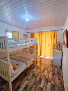 1 Schlafzimmer mit 2 Etagenbetten und Holzboden in der Unterkunft Refúgio dos Amigos casas e apartamentos in Paraty
