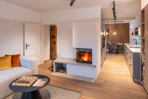 a living room with a fireplace and a kitchen at steiRerBLiCke - Traminerhaus in Hochwarth