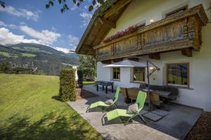 patio ze stołem i krzesłami przed domem w obiekcie Oberplunerhof Luxury Chalet Woods w mieście Colli in Pusteria