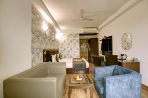 a living room with a couch and a bed at Hotel Venus Plaza in New Delhi