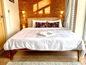 um quarto com uma cama com um edredão branco em Cambodhi - Vegan Guesthouse em Kampot