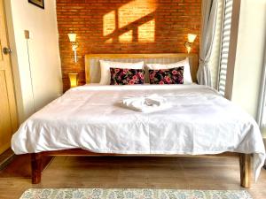 Cambodhi - Vegan Guesthouse في كامبوت: غرفة نوم مع سرير مع لحاف أبيض