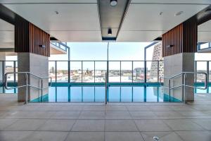 a swimming pool in a building with a large window at Urban Sanctuary in West Franklin with Pool & Gym in Adelaide